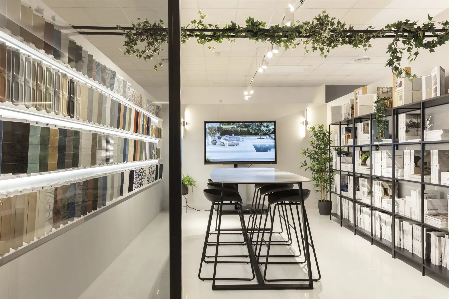 Showroom profesional con muestrarios de material en pared y zona de reuniones